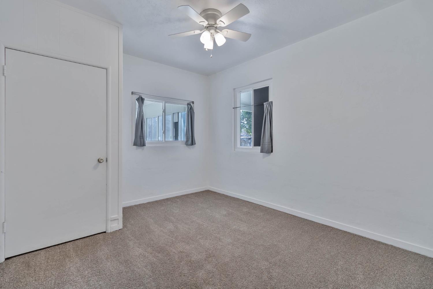 5856 East Park Cir Drive Fresno, CA 93727 - Photo 25 of 47 an empty room with windows and fan
