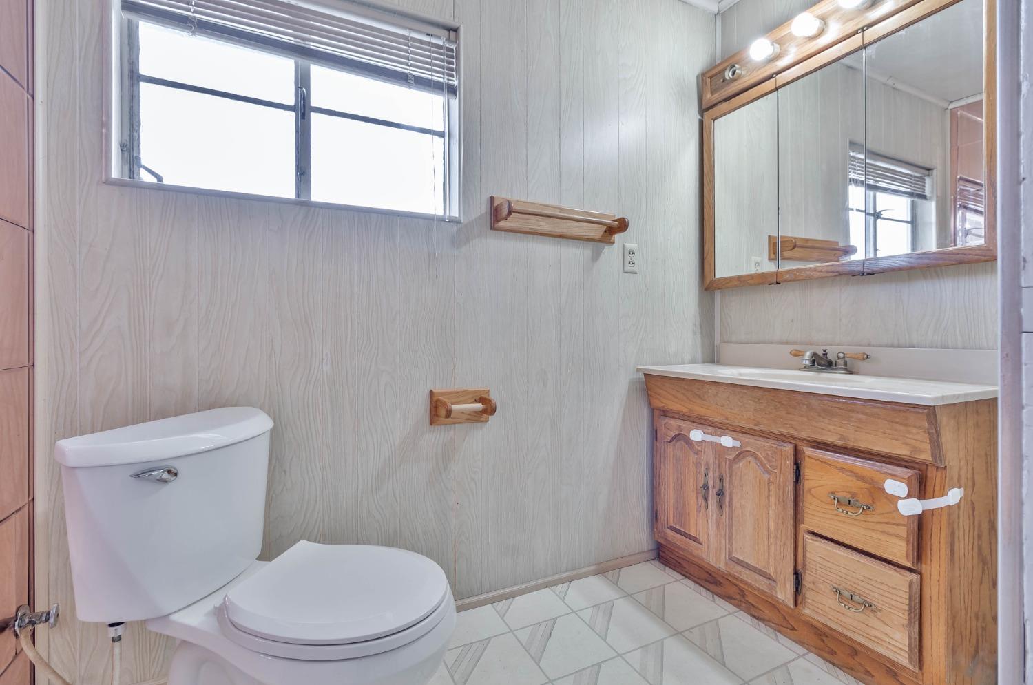 5856 East Park Cir Drive Fresno, CA 93727 - Photo 31 of 47 a bathroom with a sink a toilet and vanity