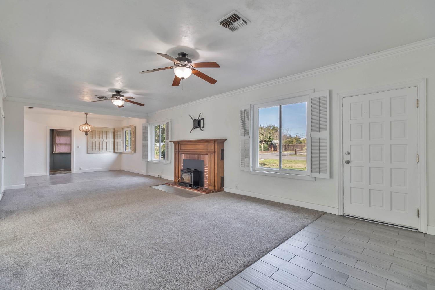 5856 East Park Cir Drive Fresno, CA 93727 - Photo 6 of 47 a view of an empty room with a fireplace and a window