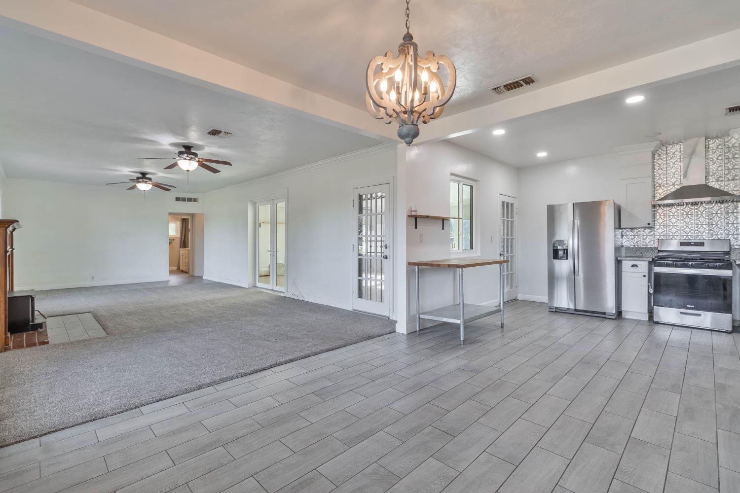 5856 East Park Cir Drive Fresno, CA 93727 - Photo 7 of 47 a view of a livingroom with kitchen and chandelier