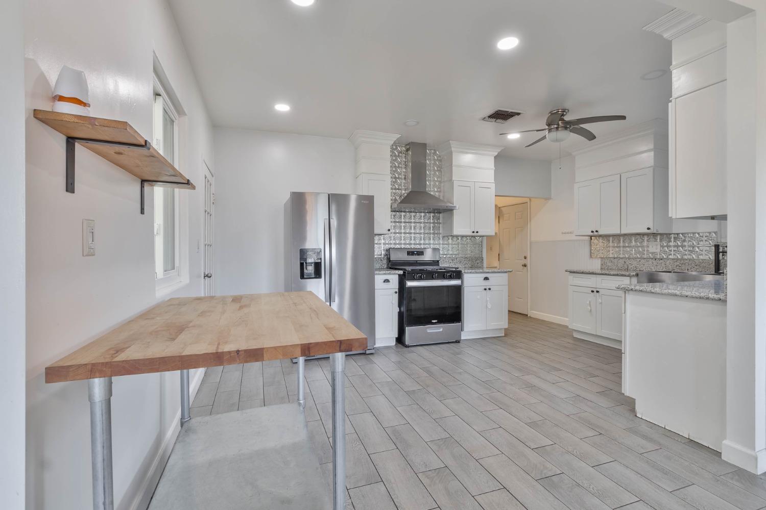 5856 East Park Cir Drive Fresno, CA 93727 - Photo 10 of 47 a kitchen with stainless steel appliances a refrigerator sink and stove