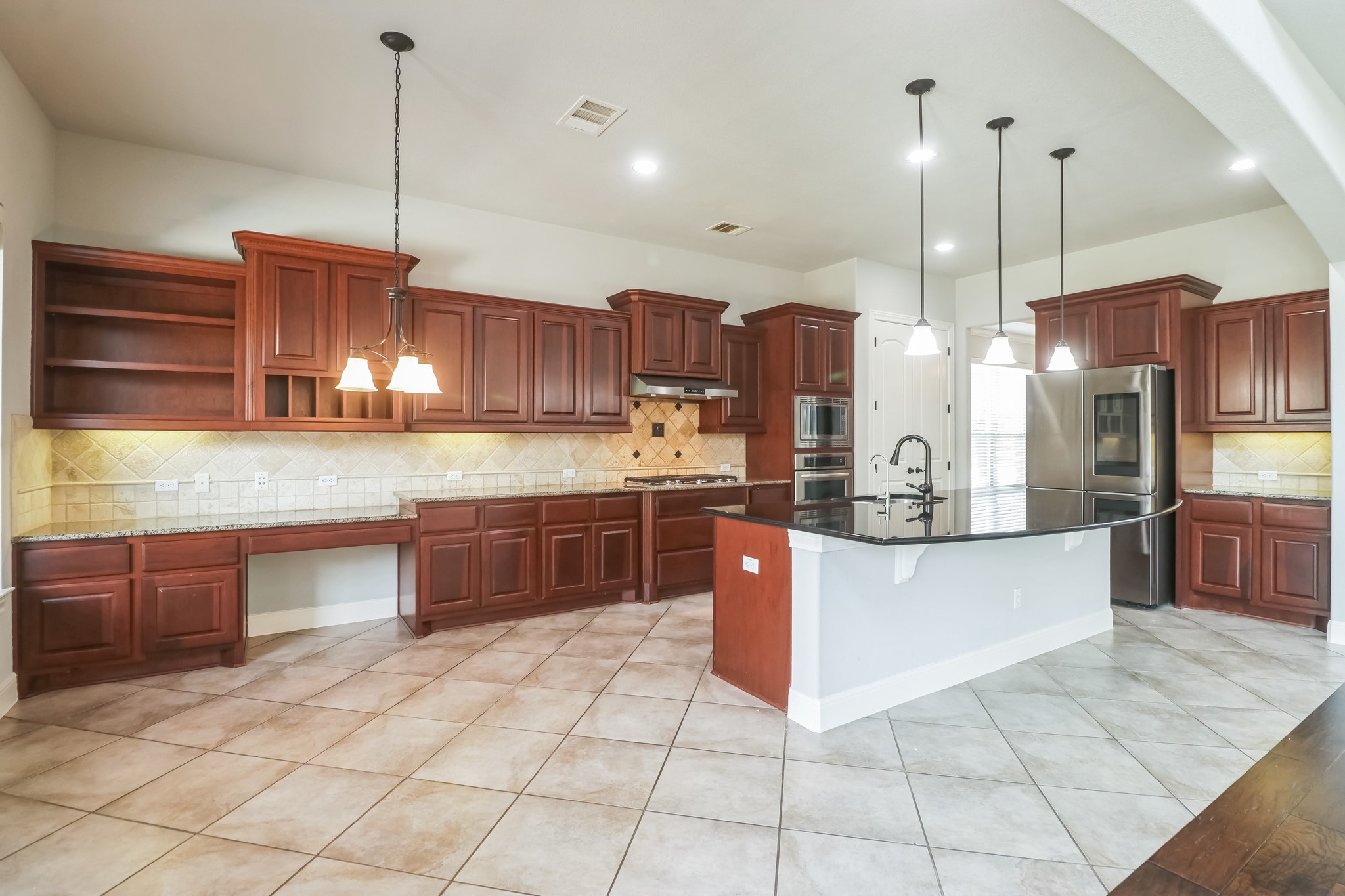 3913 Remington Road Cedar Park, TX 78613 - Photo 10 of 32 Rich wood cabinetry paired with granite countertops and a spacious island anchor this tiled kitchen.