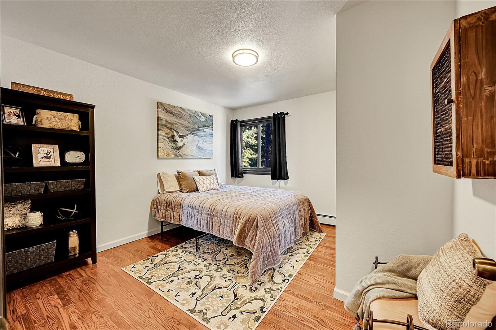 8959 South Hillview Road Morrison, CO 80465 - Photo 11 of 49 a bedroom with a bed and wooden floor