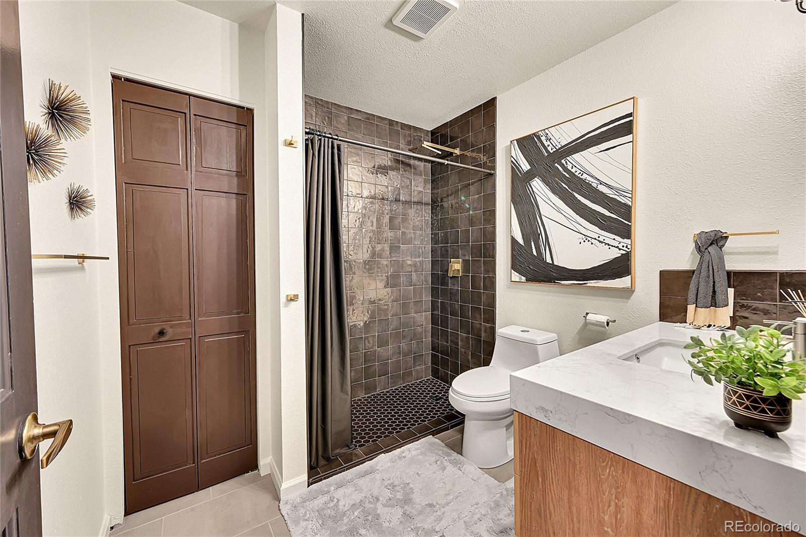 8959 South Hillview Road Morrison, CO 80465 - Photo 12 of 49 a bathroom with a sink toilet and shower
