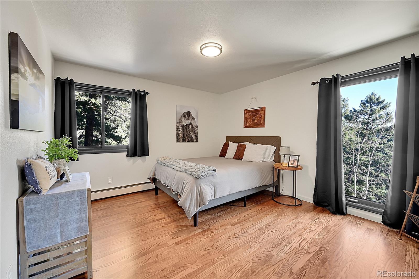 8959 South Hillview Road Morrison, CO 80465 - Photo 15 of 49 a bedroom with a large bed and a couch