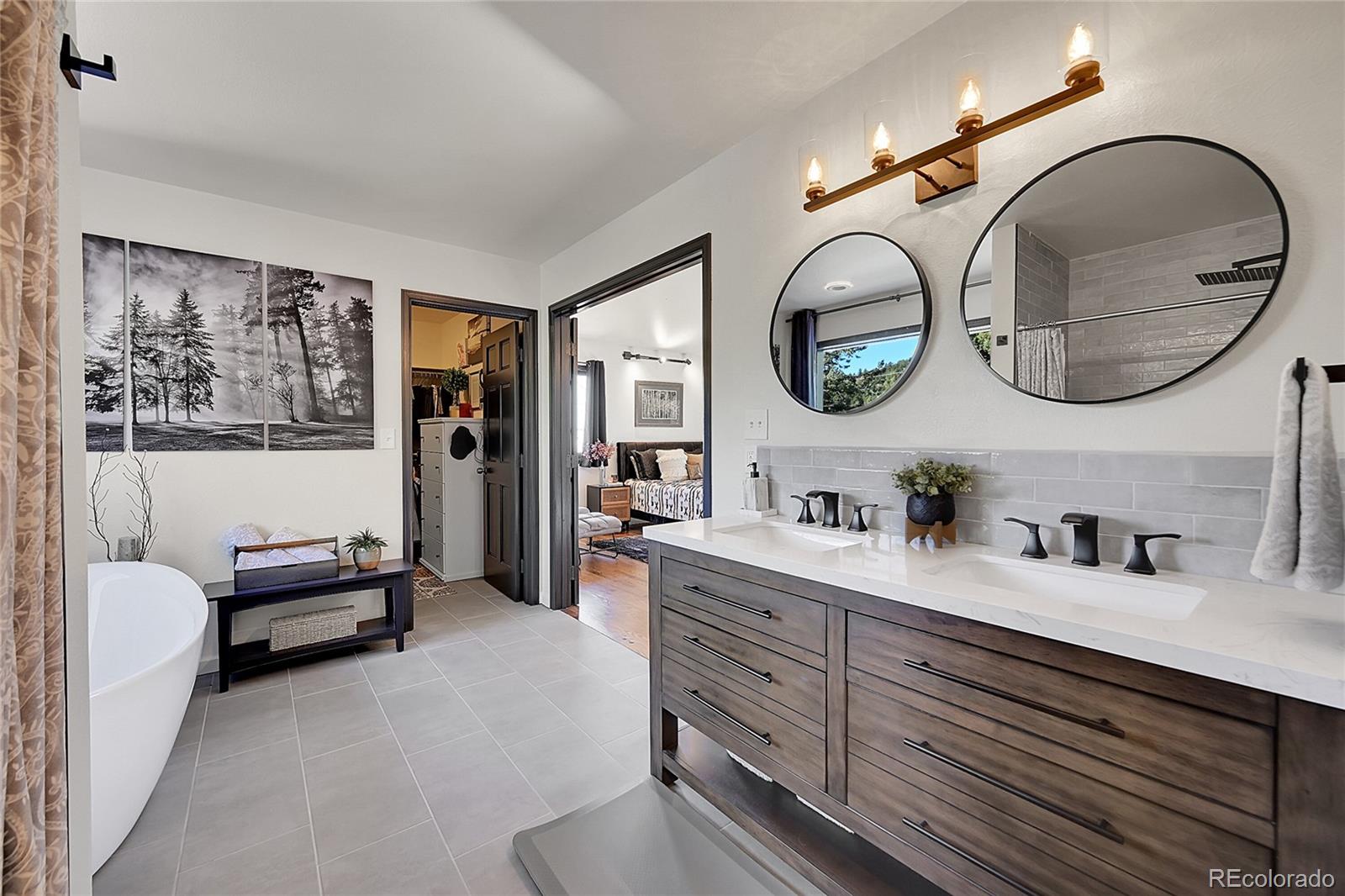 8959 South Hillview Road Morrison, CO 80465 - Photo 22 of 49 a en suite bathroom with a double vanity sink and a mirror