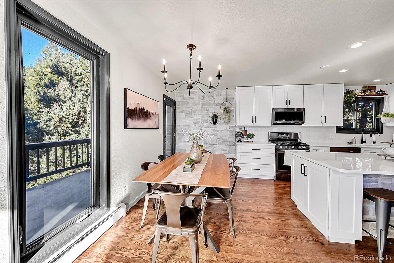 8959 South Hillview Road Morrison, CO 80465 - Photo 7 of 49 a view of a dining room with furniture a chandelier and wooden floor