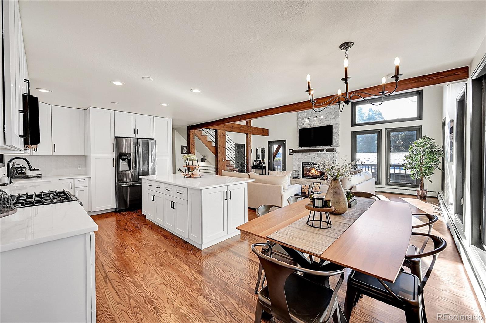 8959 South Hillview Road Morrison, CO 80465 - Photo 8 of 49 a kitchen with stainless steel appliances granite countertop a stove refrigerator a sink dishwasher a dining table and chairs with wooden floor