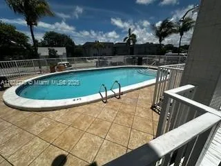 a view of a swimming pool with a patio and a yard