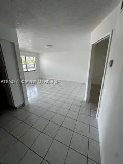 a view of a livingroom with an empty space and a window