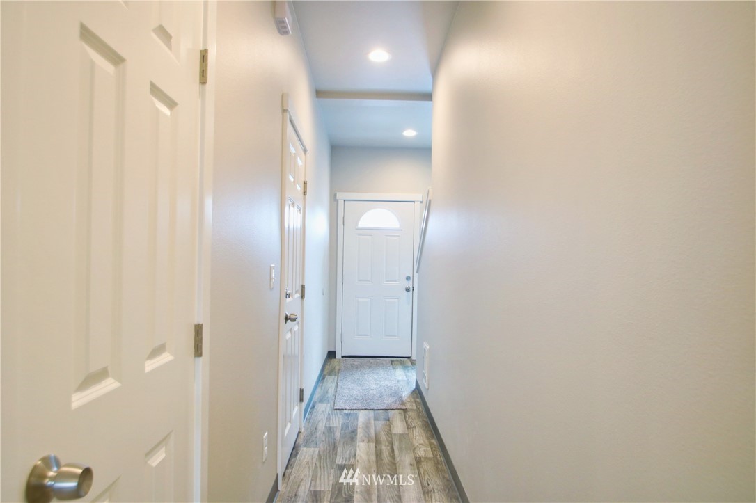 705 Peterson Road Burlington, WA 98233 - Photo 4 of 30 a view of a hallway with wooden floor and a bathroom