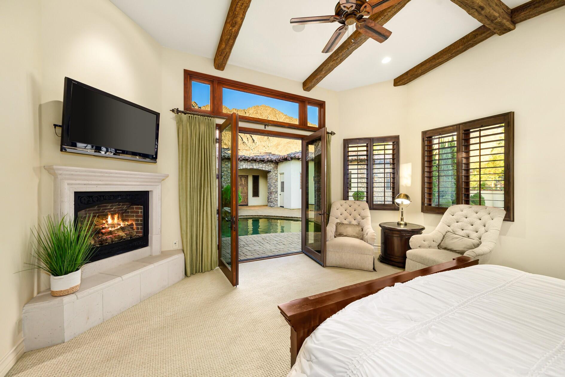 77169 Casa Del Sol La Quinta, CA 92253 - Photo 18 of 50 a bedroom with a large bed and a fireplace