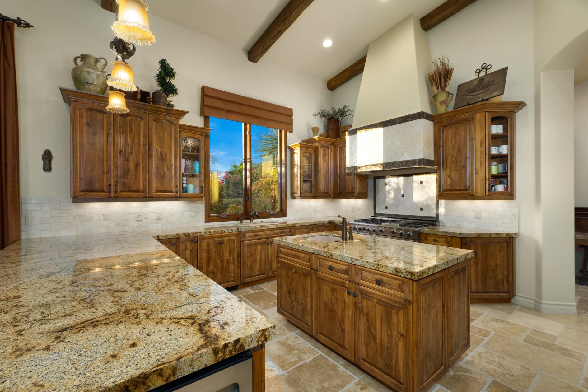 77169 Casa Del Sol La Quinta, CA 92253 - Photo 10 of 50 a kitchen with stainless steel appliances granite countertop wooden cabinets and sink