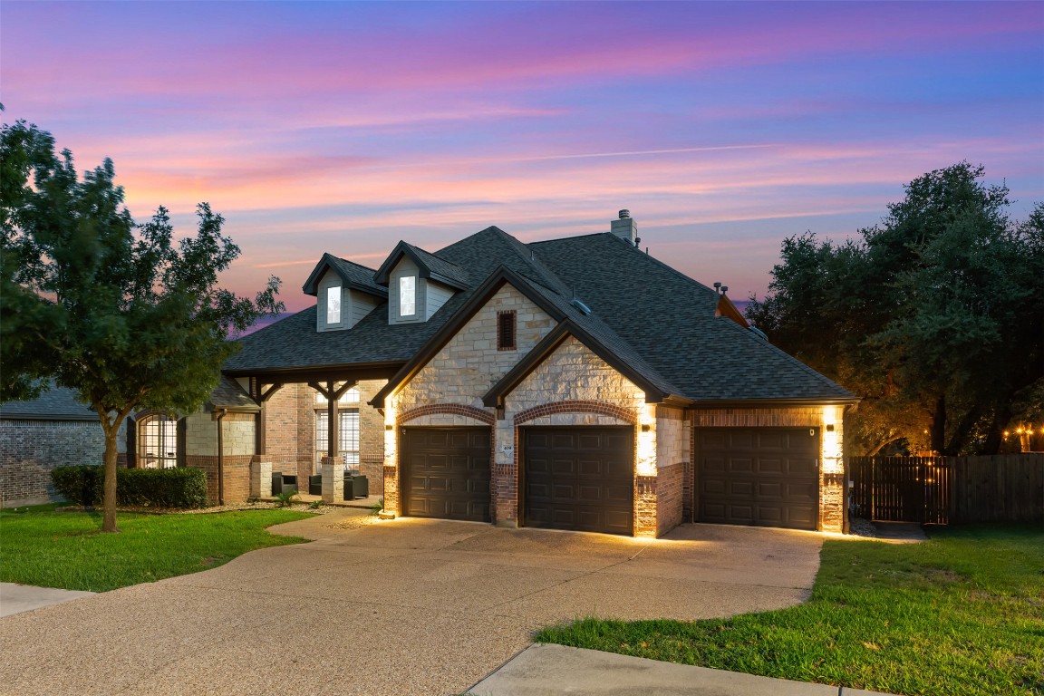 a front view of a house with a yard and trees