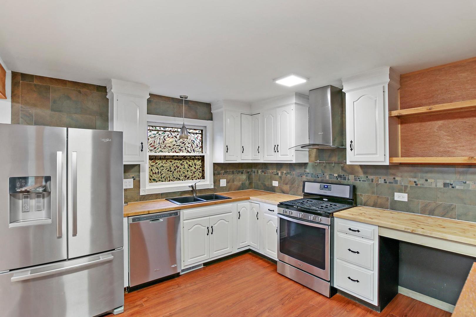 703 Crestview Drive Ingleside, IL 60041 - Photo 10 of 28 a kitchen with white cabinets and white appliances