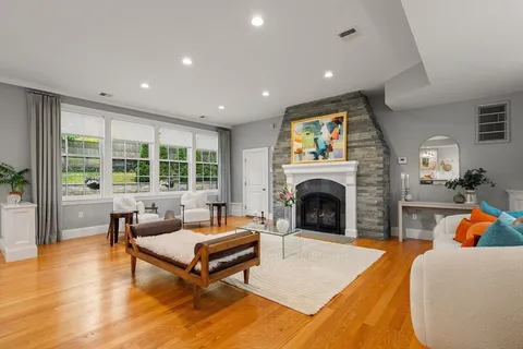 a living room with furniture a fireplace and a floor to ceiling window