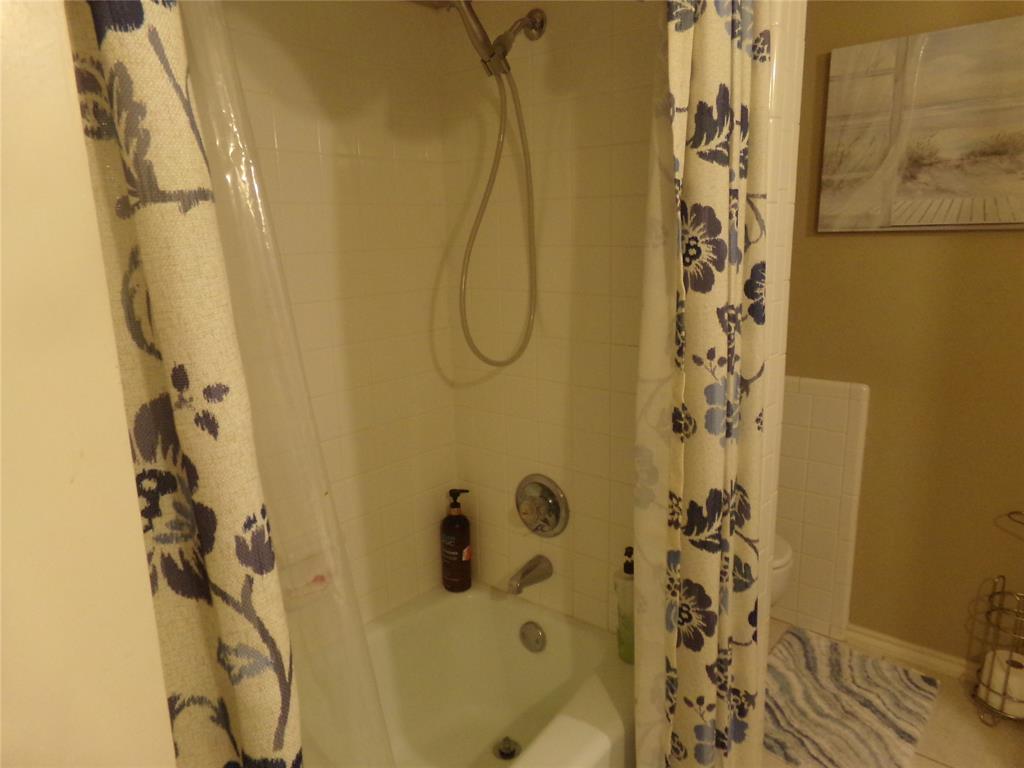 5110 Wedgefield Road Granbury, TX 76049 - Photo 18 of 23 White tiled shower surround with a chrome shower head and faucet