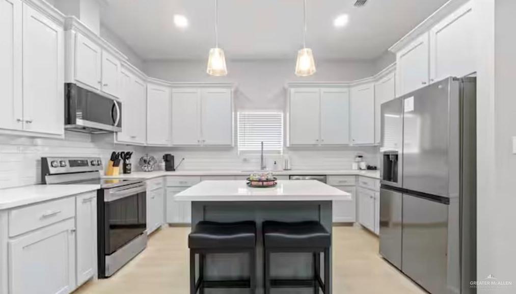 2310 Treasure Cove Harlingen, TX 78550 - Photo 18 of 23 a kitchen with stainless steel appliances a sink stove refrigerator and cabinets
