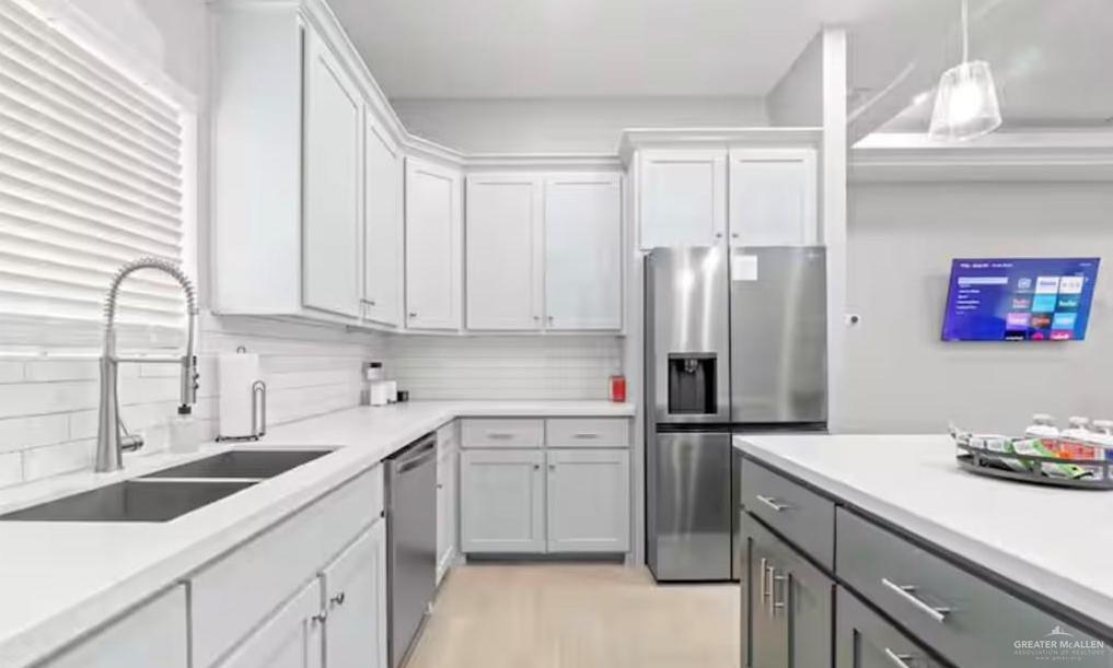 2310 Treasure Cove Harlingen, TX 78550 - Photo 21 of 23 a kitchen with a sink cabinets and stainless steel appliances