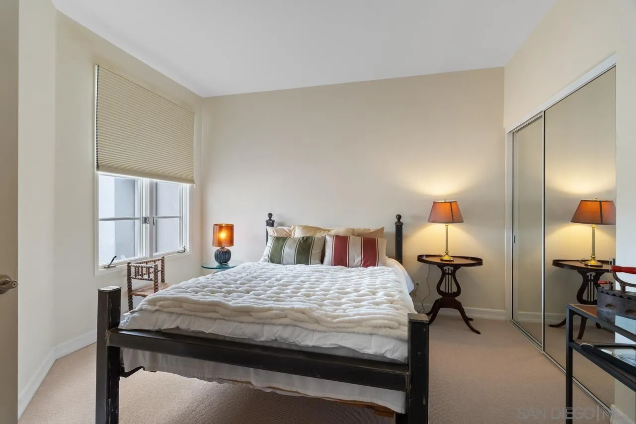 3128 Almahurst Row La Jolla, CA 92037 - Photo 16 of 21 a bedroom with a bed a mirror and lamp on table