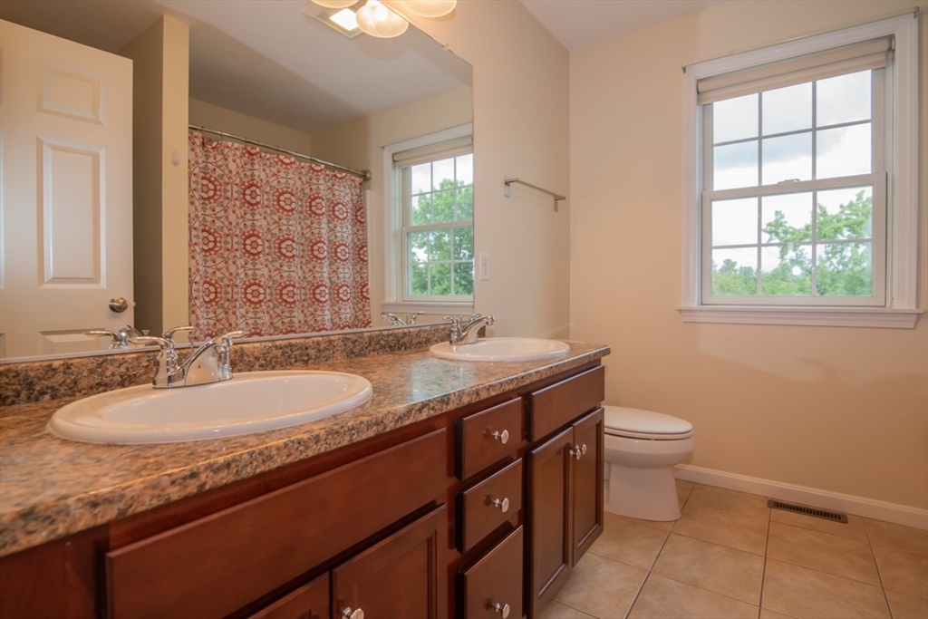 1975 Middlesex Street, Unit 51 Lowell, MA 01851 - Photo 16 of 34 a bathroom with a granite countertop sink a toilet and a window