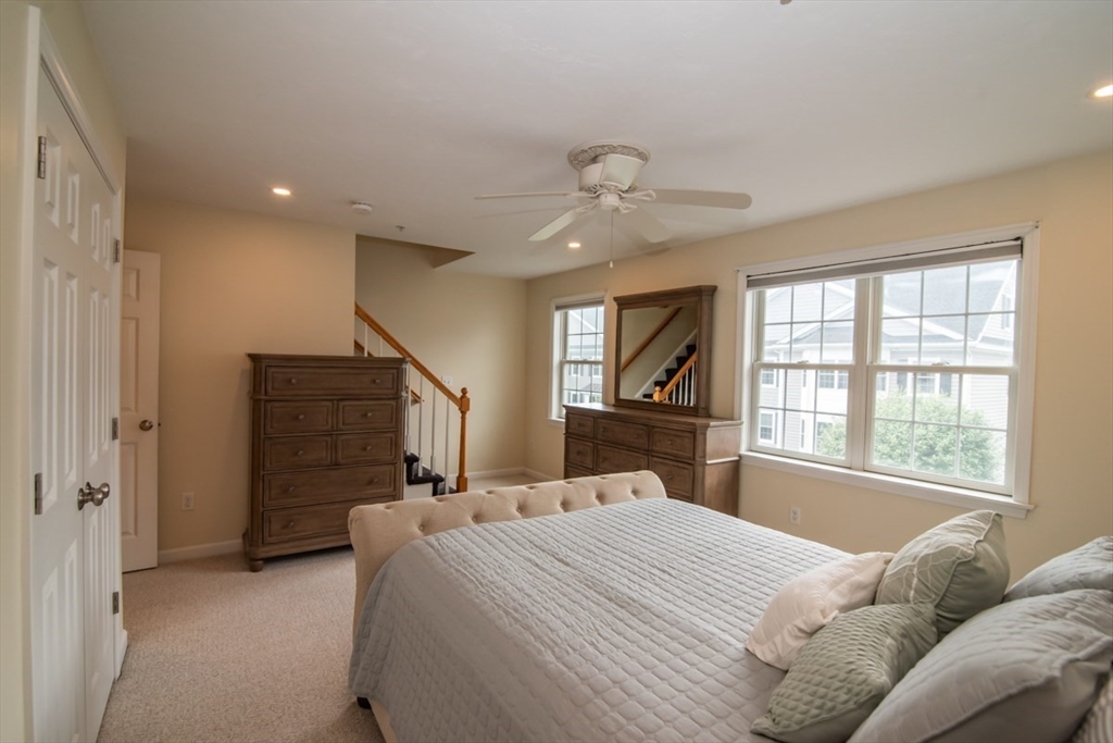 1975 Middlesex Street, Unit 51 Lowell, MA 01851 - Photo 20 of 34 a bedroom with a large bed and a chandelier