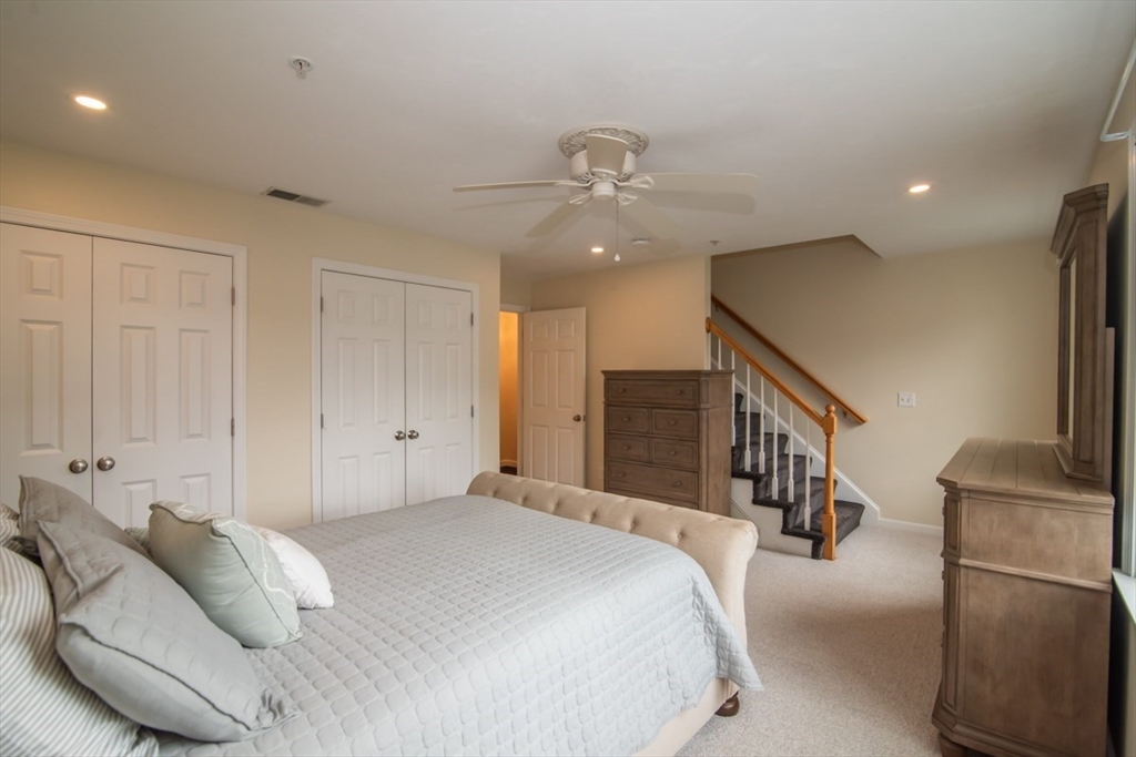 1975 Middlesex Street, Unit 51 Lowell, MA 01851 - Photo 21 of 34 a bedroom with a bed a chandelier and a flat screen tv