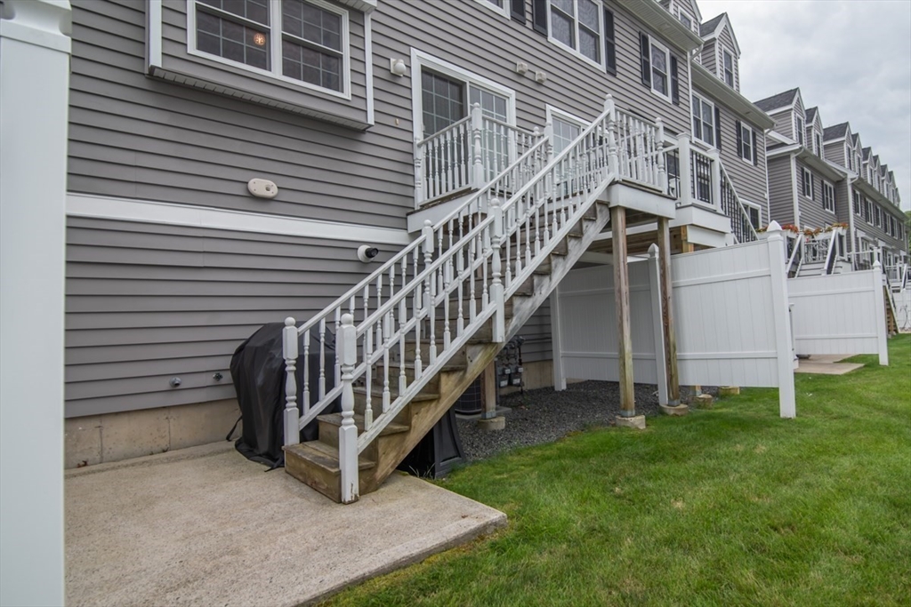 1975 Middlesex Street, Unit 51 Lowell, MA 01851 - Photo 32 of 34 a view of wooden house with a yard and deck