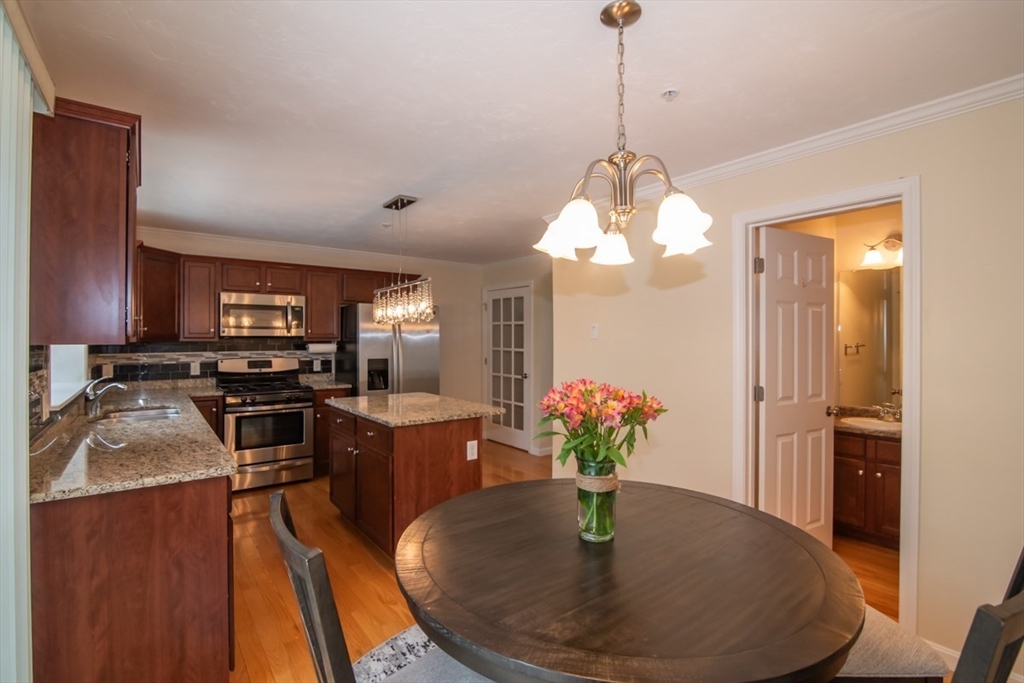1975 Middlesex Street, Unit 51 Lowell, MA 01851 - Photo 4 of 34 a kitchen with sink refrigerator dining table and chairs