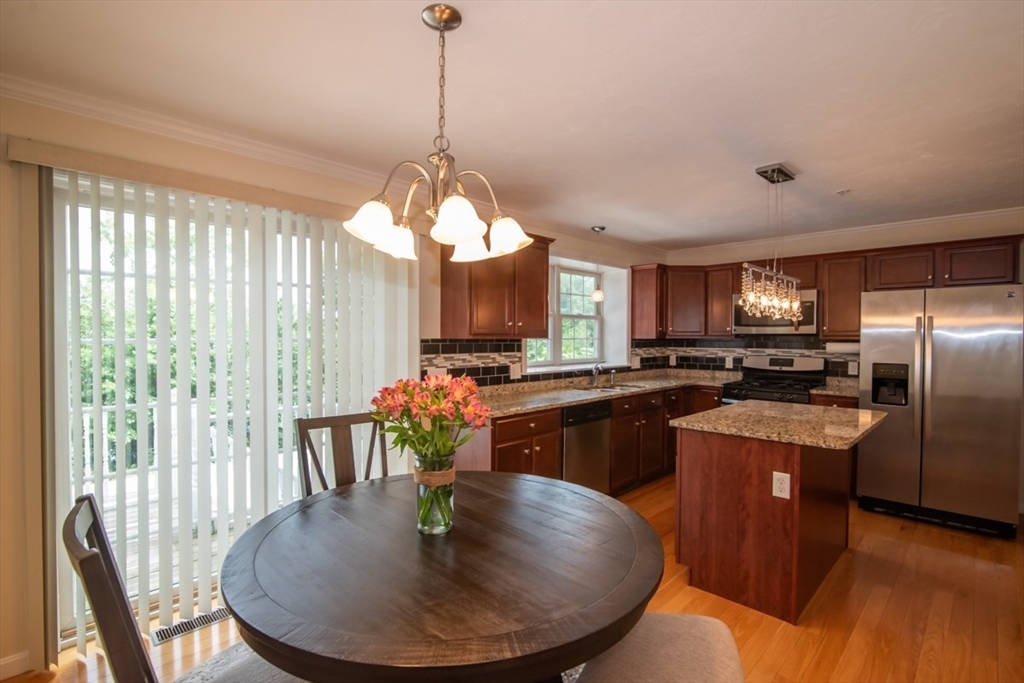 1975 Middlesex Street, Unit 51 Lowell, MA 01851 - Photo 5 of 34 a kitchen with stainless steel appliances granite countertop a kitchen island a stove a table and chairs