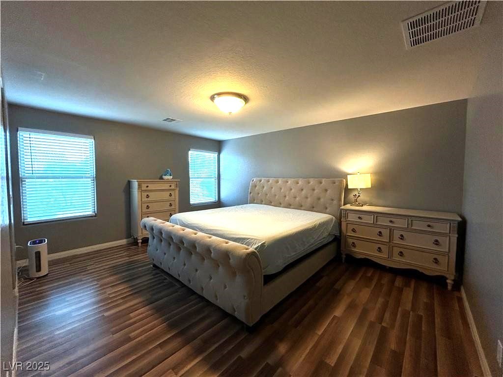 8977 Melridge Road Las Vegas, NV 89148 - Photo 25 of 35 Bedroom with visible vents, dark wood-style flooring, and baseboards