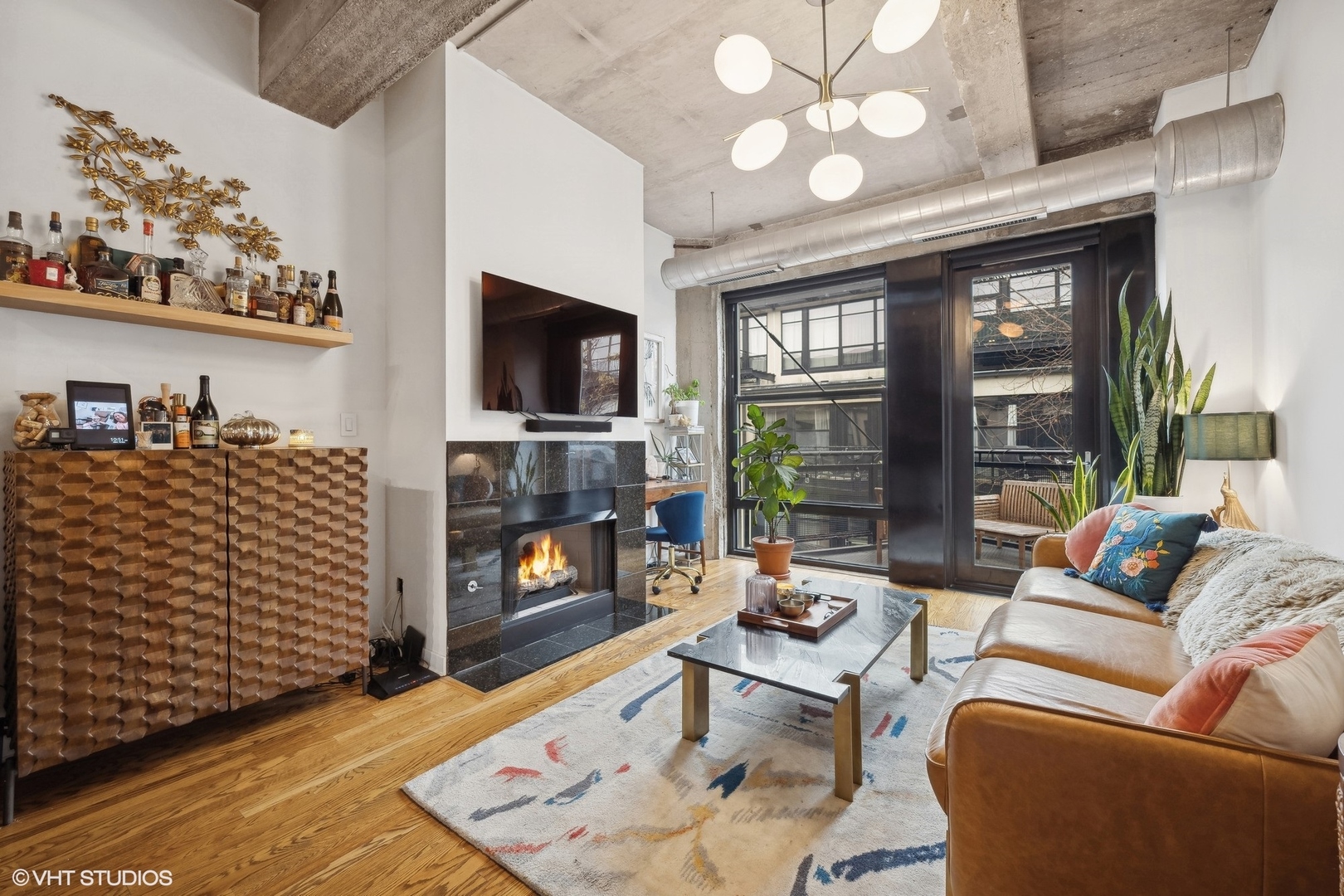 1069 West 14th Place, Unit 305 Chicago, IL 60608 - Photo 3 of 15 a living room with furniture a flat screen tv and a fireplace