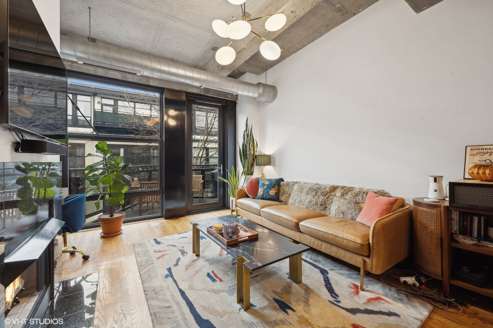 1069 West 14th Place, Unit 305 Chicago, IL 60608 - Photo 4 of 15 a living room with furniture a chandelier and a large window
