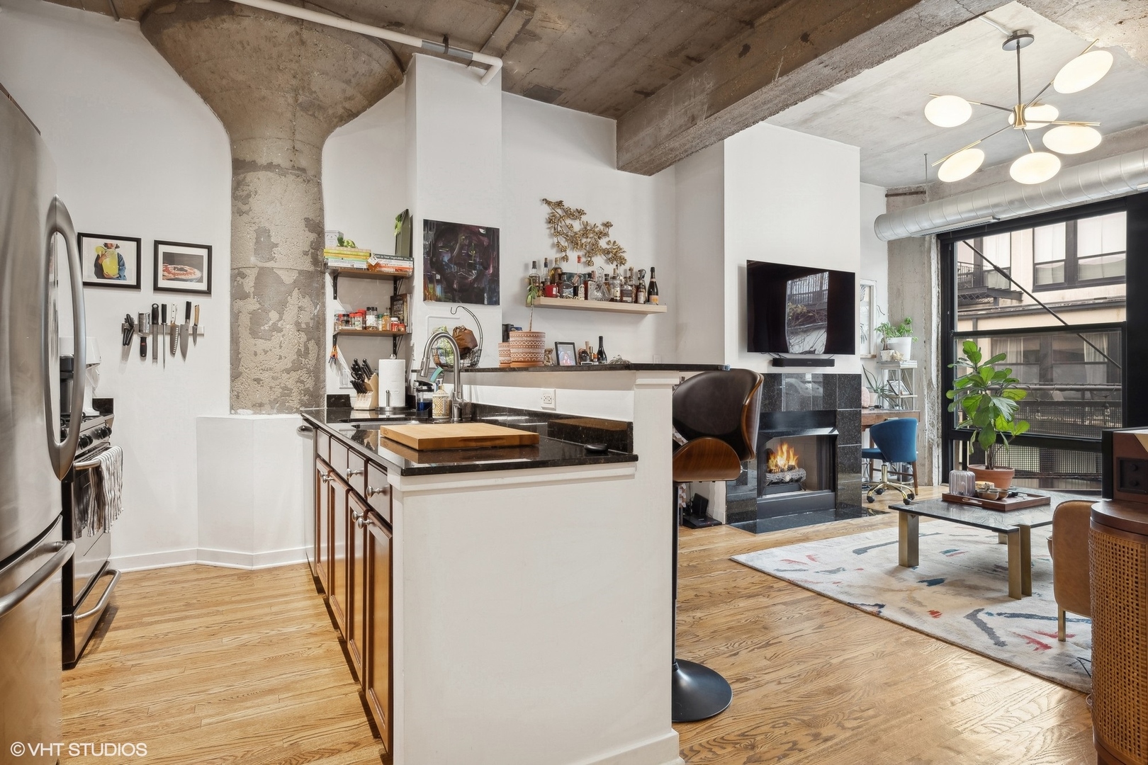 1069 West 14th Place, Unit 305 Chicago, IL 60608 - Photo 7 of 15 a view of a kitchen with furniture and a flat screen tv