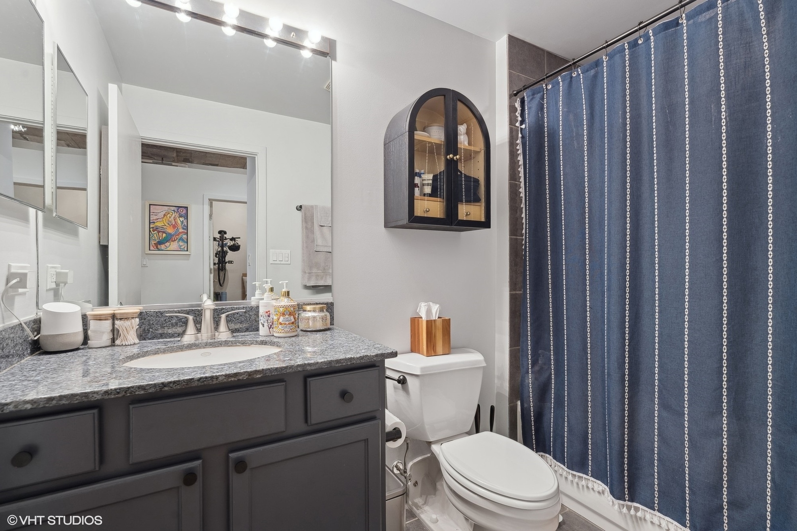 1069 West 14th Place, Unit 305 Chicago, IL 60608 - Photo 9 of 15 a bathroom with a toilet a sink and mirror