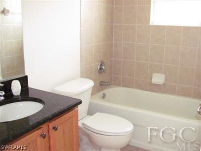 2805 23rd Street Southwest Lehigh Acres, FL 33976 - Photo 7 of 10 a bathroom with a granite countertop sink toilet and bathtub