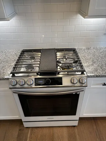 a stove top oven sitting inside of a kitchen