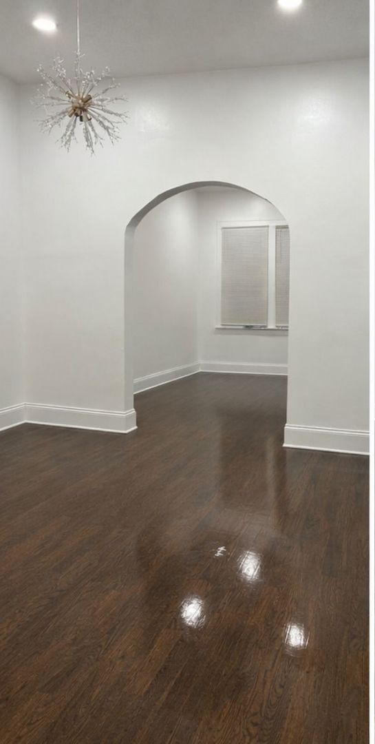 5543 South Shields Avenue Chicago, IL 60621 - Photo 3 of 12 wooden floor in an empty room with a window
