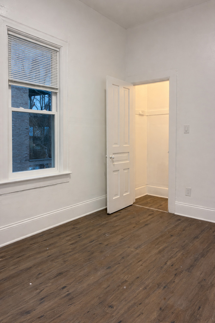 5543 South Shields Avenue Chicago, IL 60621 - Photo 5 of 12 a view of an empty room with wooden floor and a window