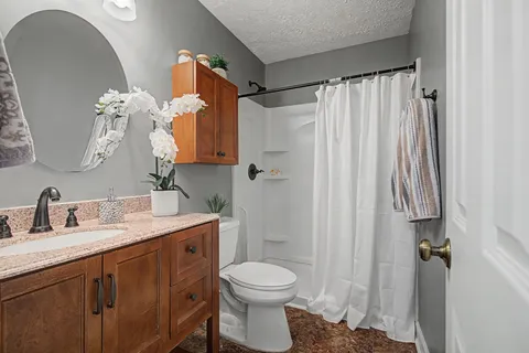 a bathroom with a sink vanity mirror and toilet