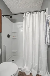 a bathroom with a shower curtain and a toilet