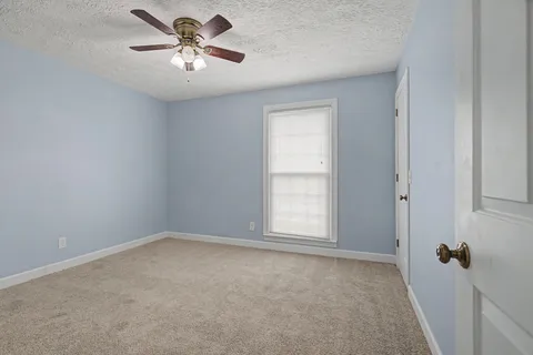a view of a room with a ceiling fan and a window