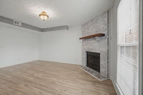 a view of empty room with wooden floor and fireplace