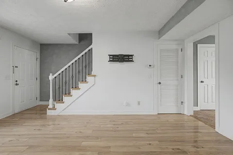 a view of entryway and hall with wooden floor