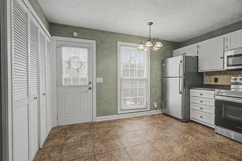 an empty room with windows and cabinet