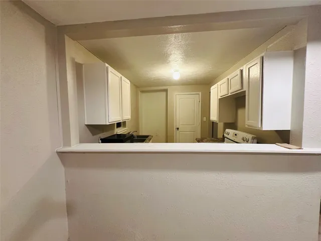 a view of a kitchen with a sink and a mirror