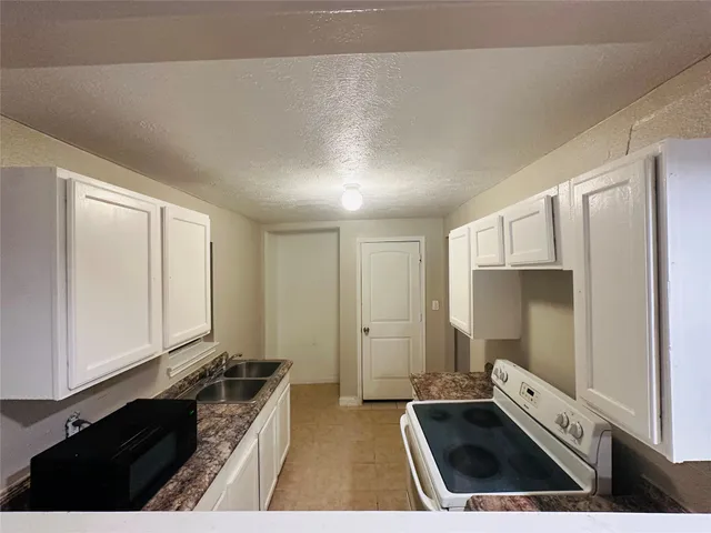 a kitchen with granite countertop a stove and a refrigerator