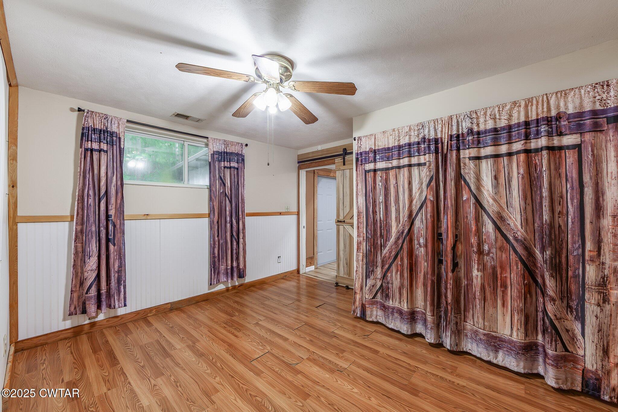 1276 Mifflin Road Jackson, TN 38301 - Photo 15 of 35 a view of empty room with wooden floor and fan