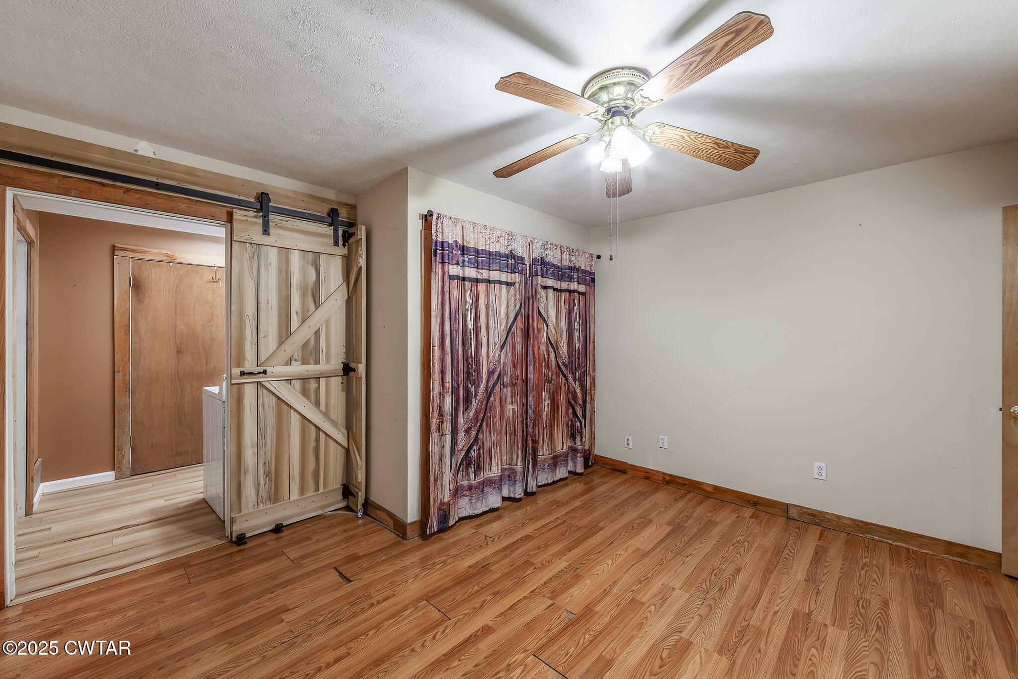 1276 Mifflin Road Jackson, TN 38301 - Photo 16 of 35 an empty room with wooden floor fan and windows