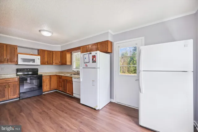 a kitchen with granite countertop a refrigerator and a stove top oven